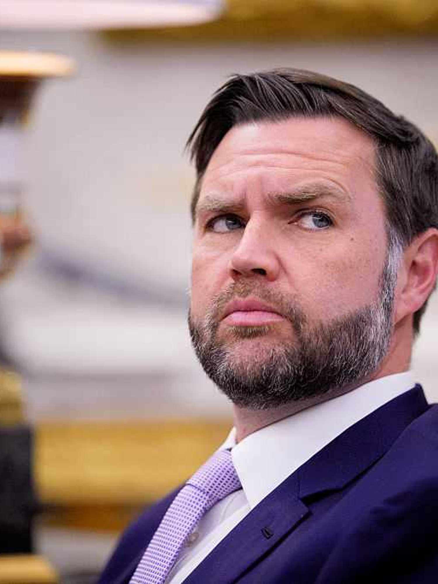 JD Vance looks at something to his left while sitting in the Oval Office.