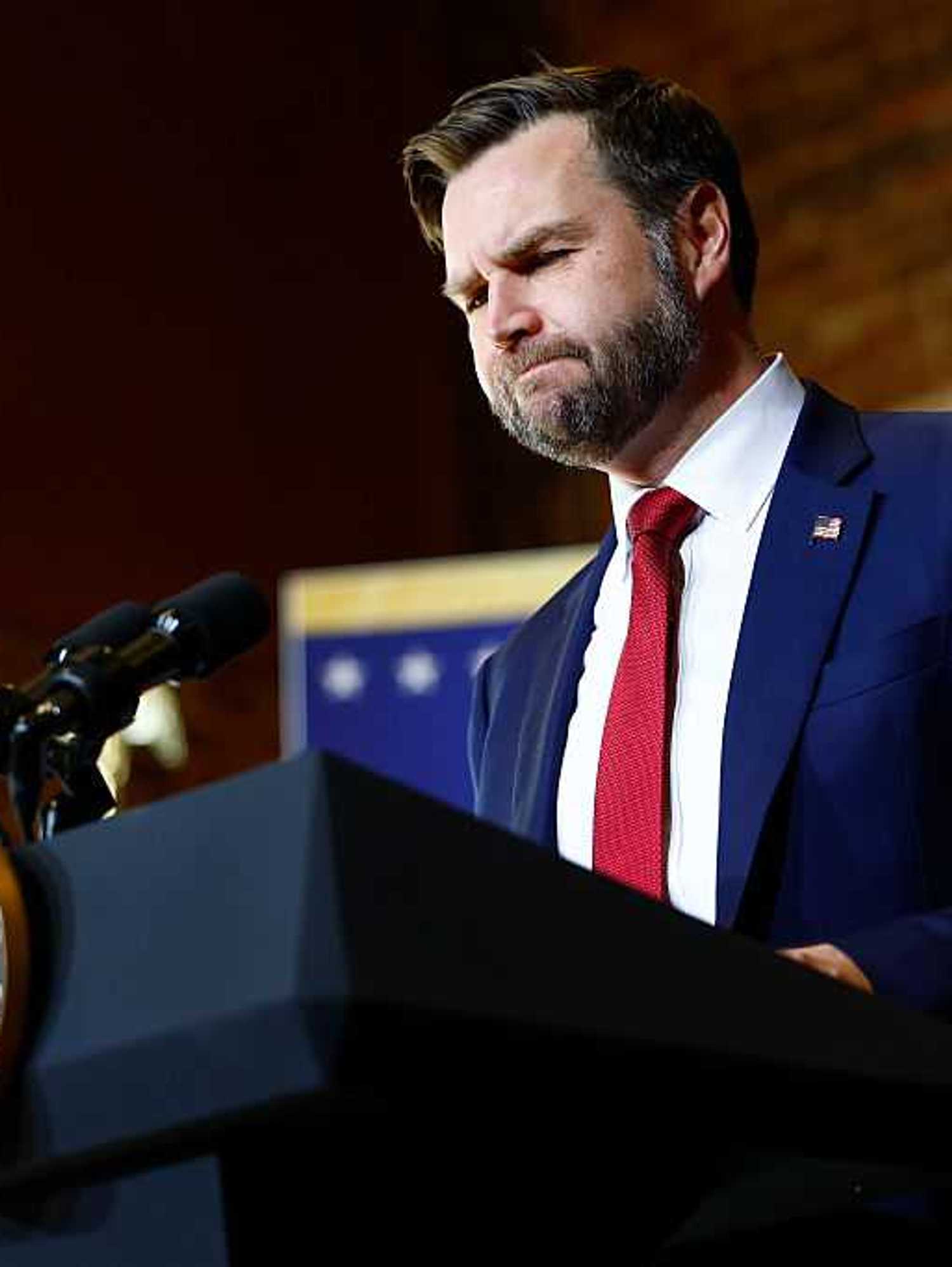 JD Vance pauses as he stands behind the vice presidential lectern during a speech in North Carolina.