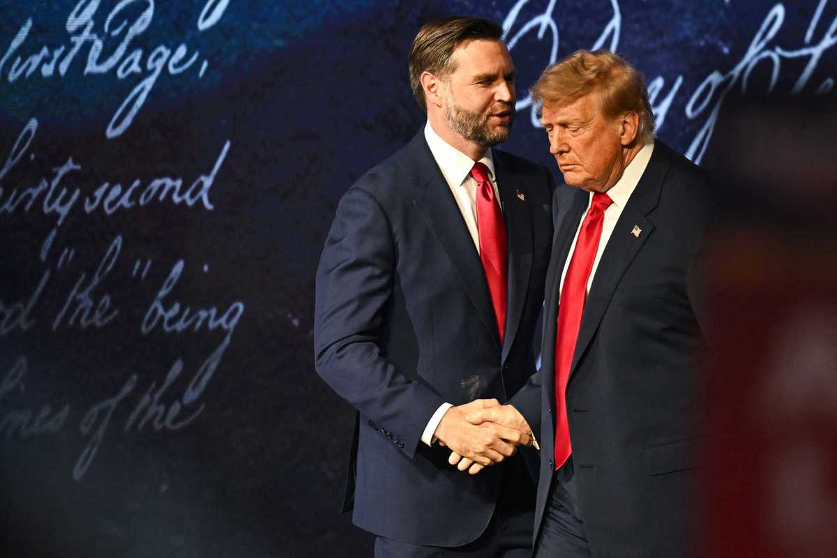 JD Vance shakes Donald Trump's hand on stage at the midterm convention.