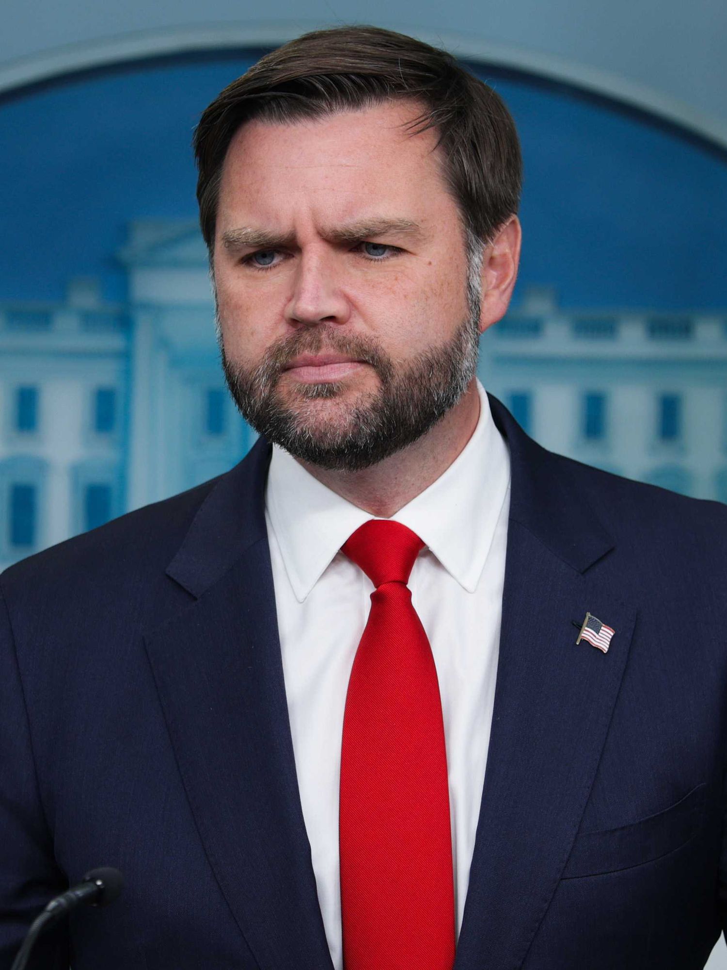 JD Vance standing behind a lectern in the White House press briefing room.