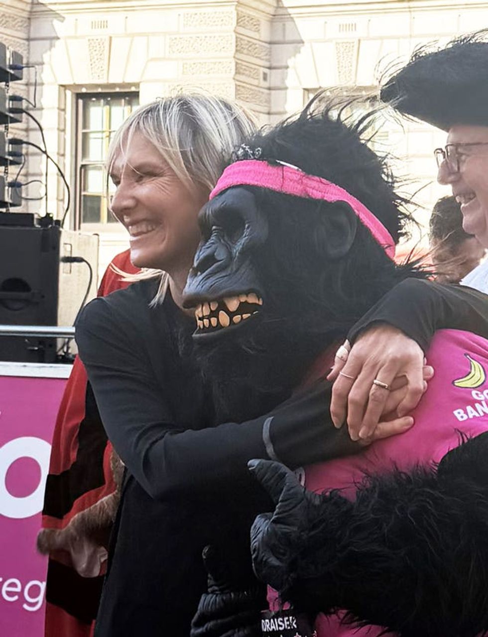 Jo Whiley hugs a runner dressed as a gorilla