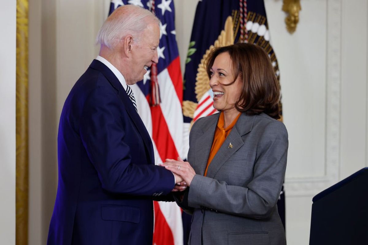 Joe Biden clasps the hands of his Vice President Kamala Harris