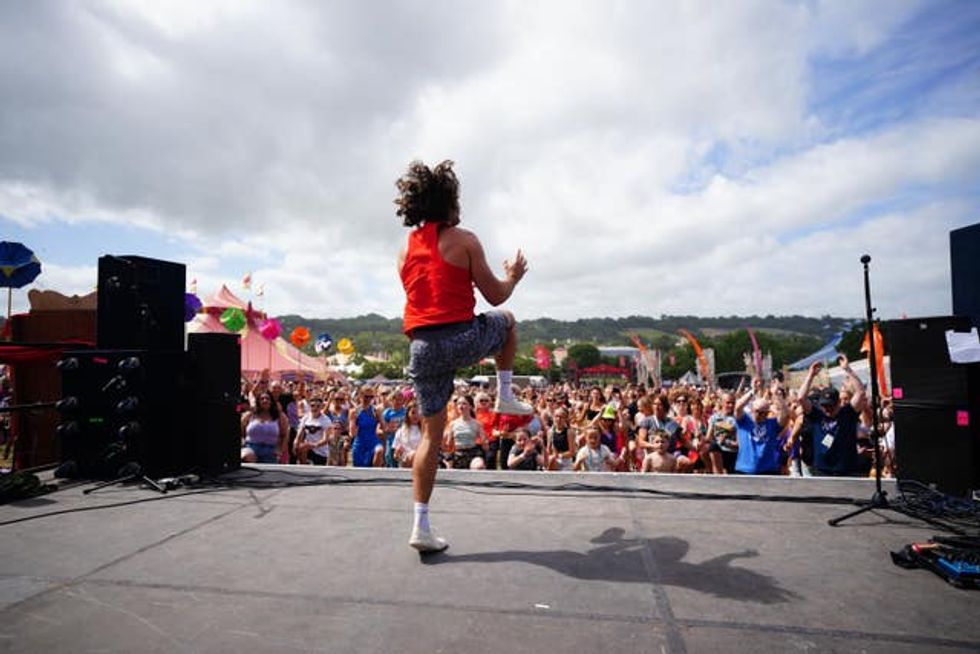 Joe Wicks jumps up and down on stage in front of crowds of people