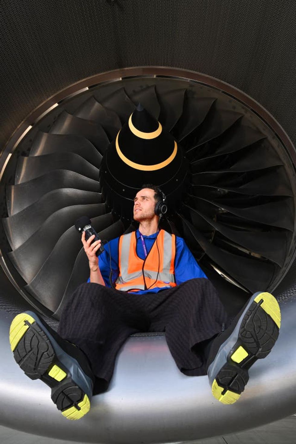 Jordan Rakei sitting next to a plane engine
