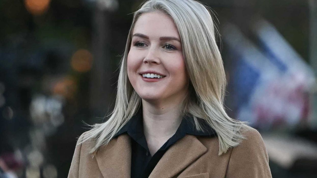 Karoline Leavitt, a white woman with short blonde hair and a brown coat, smiling.
