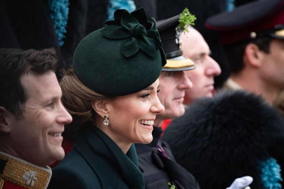 Kate poses for a photo during a visit to the Irish Guards