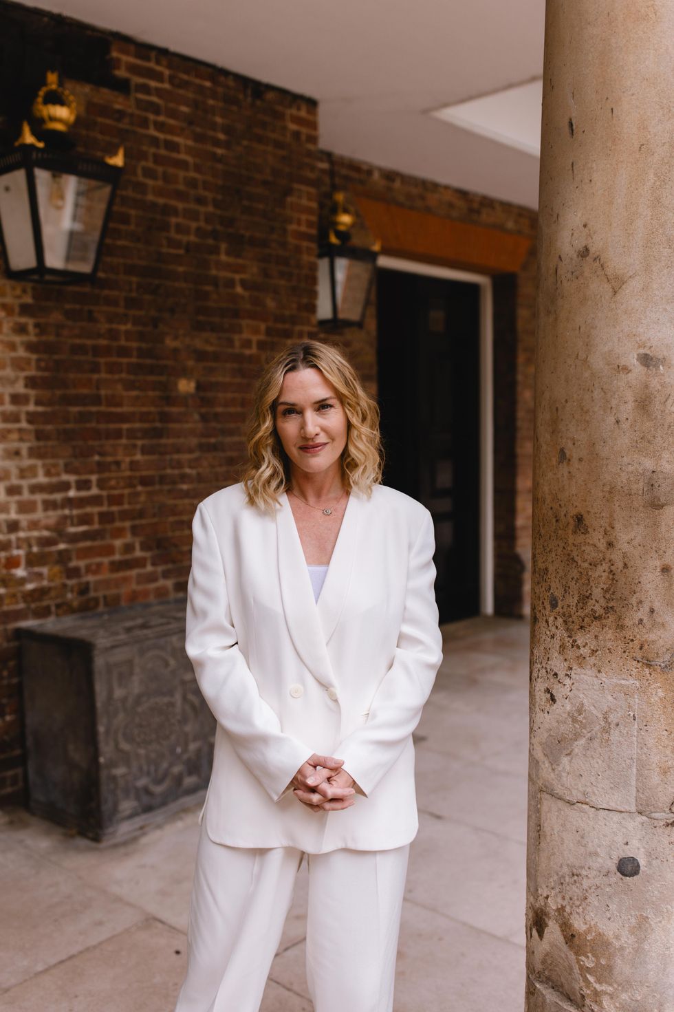 Kate Winslet pictured standing with her hands clasped