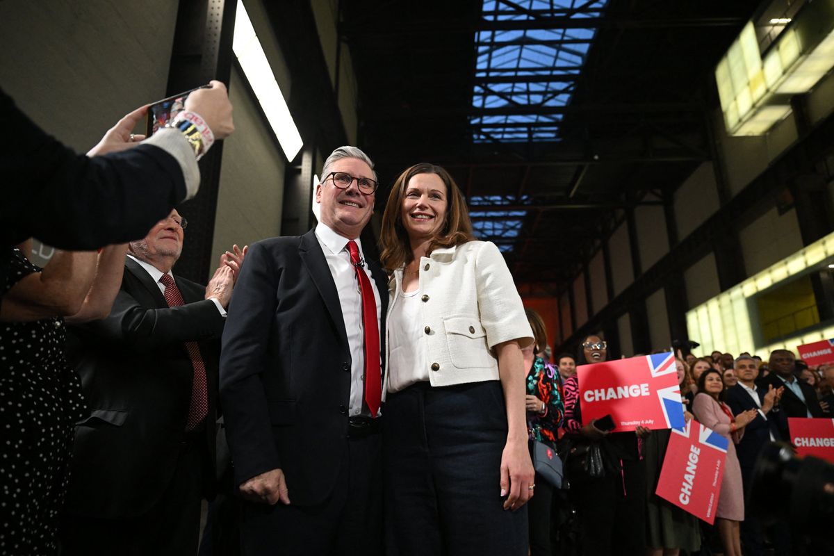 Keir and Victoria Starmer smile as fans watch on as the general election results come in