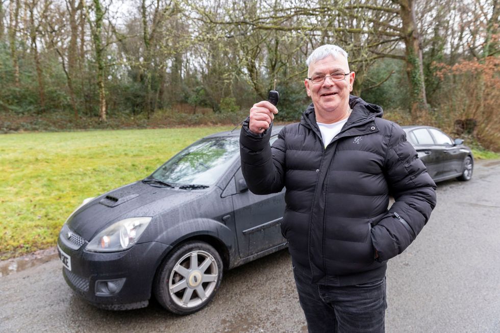 Kevin Jones standing in front of a car and holding up a key