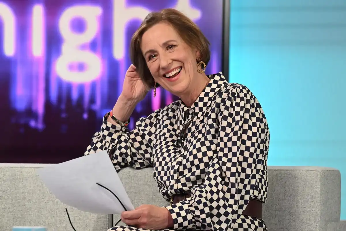 Kirsty Wark sits on the set of Newsnight holding her script, wearing a black and white chequered outfit