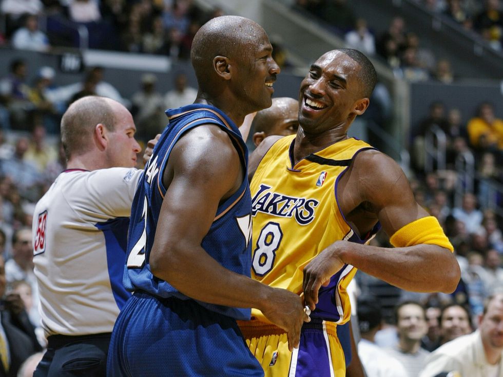 Kobe Bryant #8 of the Los Angeles Lakers shares a laugh with Michael Jordan #23 of the Washington Wizards during the game at Staples Center on March 28, 2003 in Los Angeles, California.