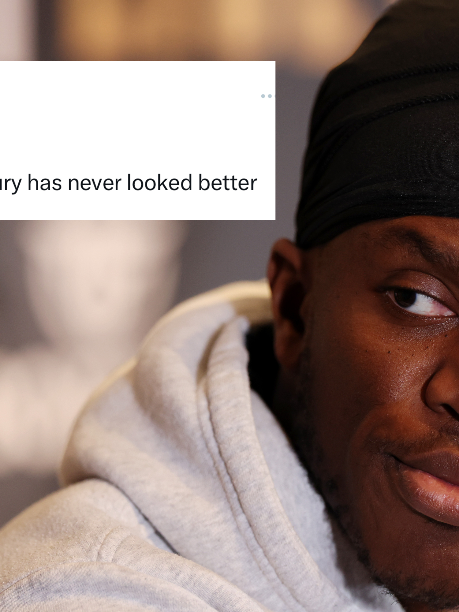 KSI, a Black man wearing a black durag and a grey hoodie, looks to his right at something off-camera. Inset top left, a tweet from KSI reads: 'Can't lie, Tommy Fury has never looked better'..