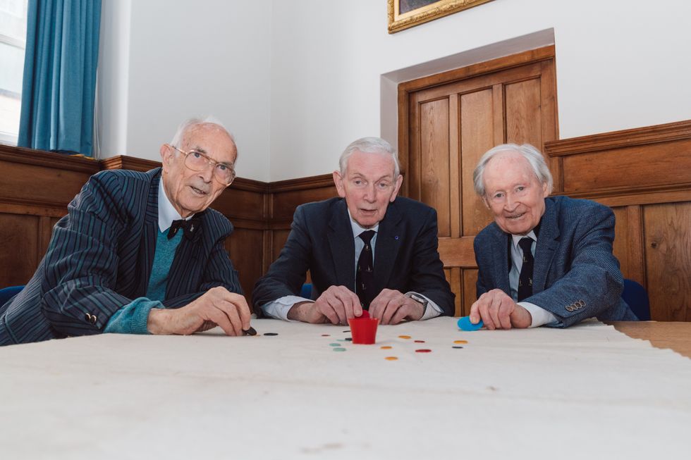 (L-R) Bill Steen, Peter Downes and Lawford Howells celebrate the 70th anniversary of competitive tiddlywinks. (Cambridge University/ PA)