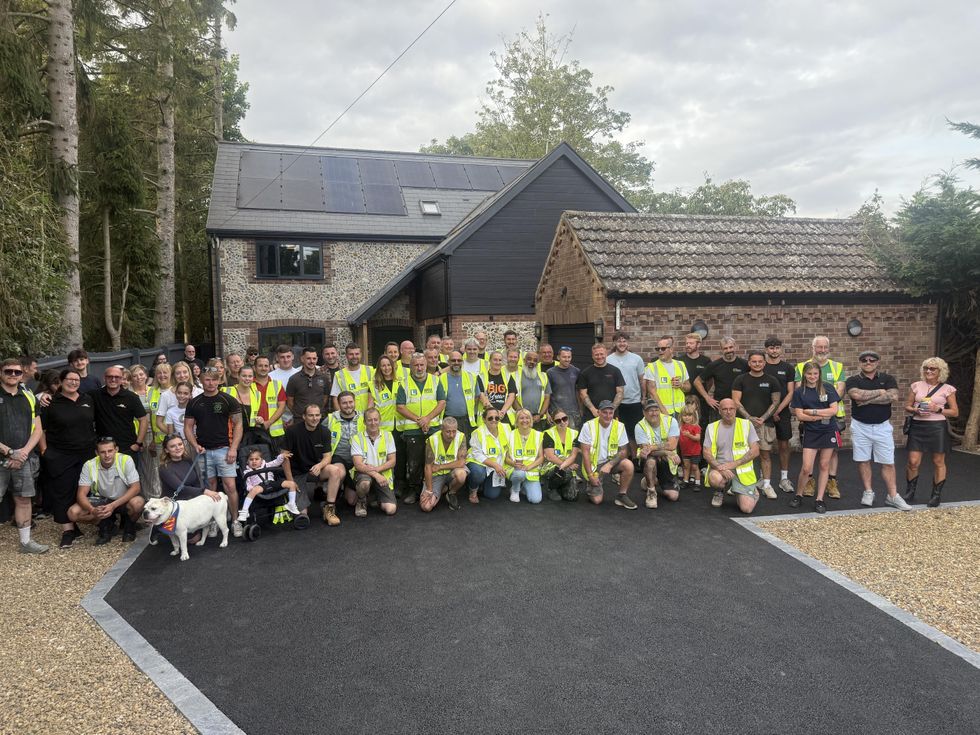 Large group of people posing for a group photo outside a house