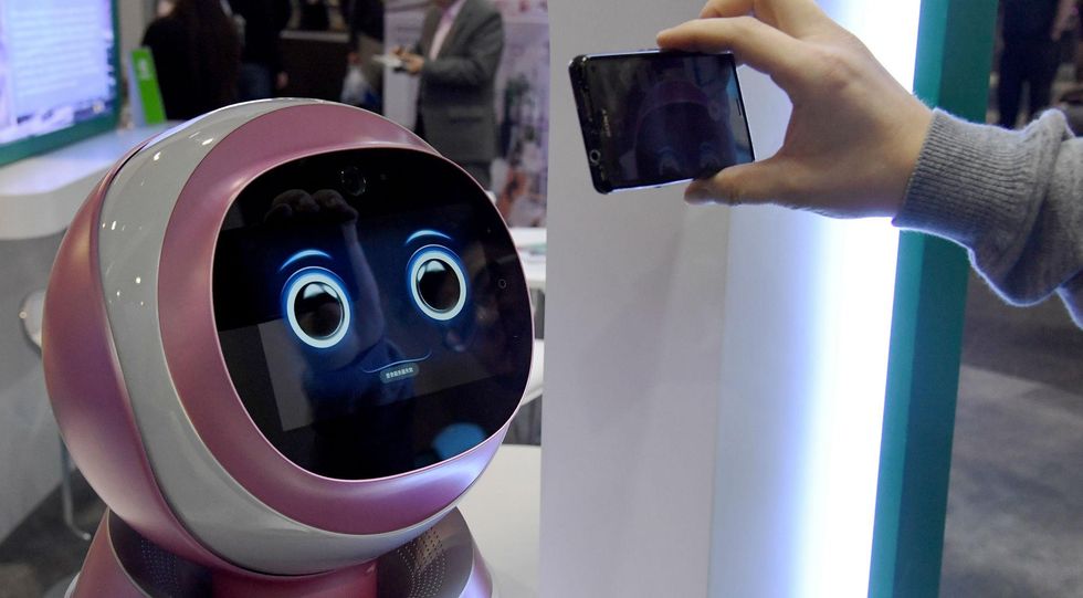 LAS VEGAS, NV - JANUARY 05: An attendee records images of a prototype Kikoo autonomous robot for children made by Hanwuji Intelligence at CES 2017. Picture: