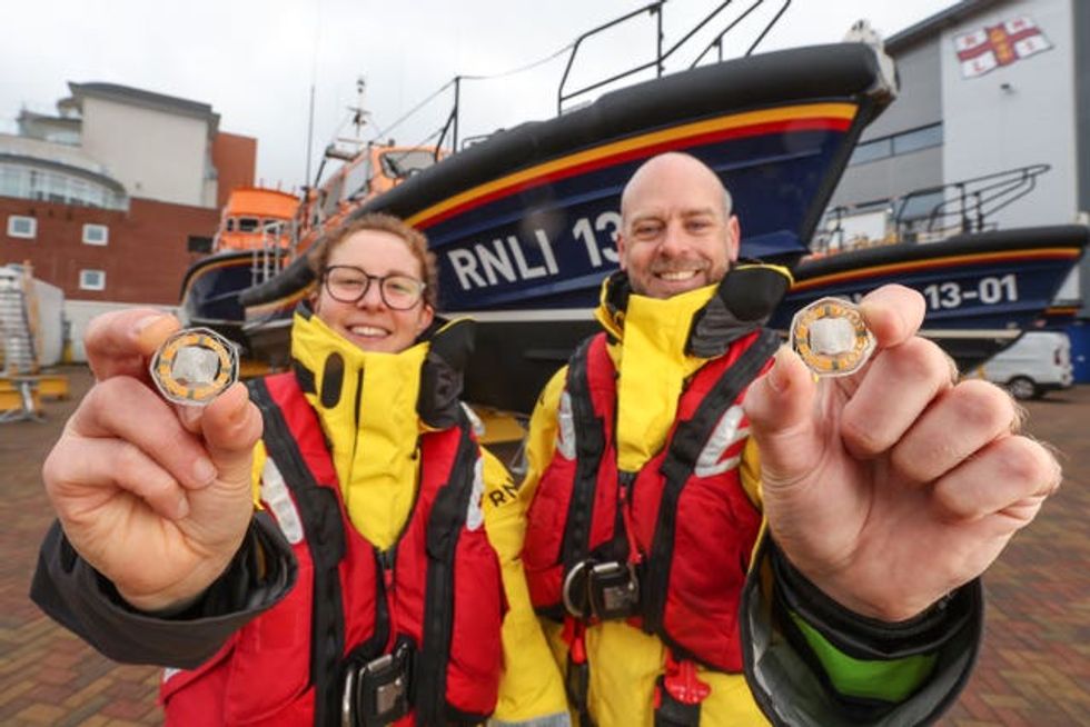 Lauren Baker-Little and Steve Porter of the RNLI show off the coin