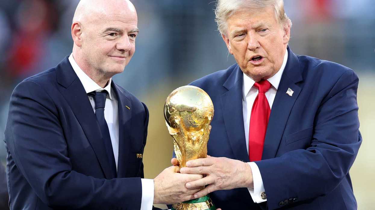 Left, Gianni Infantino and right, Donald Trump, both holding the golden World Cup trophy in the middle of them.