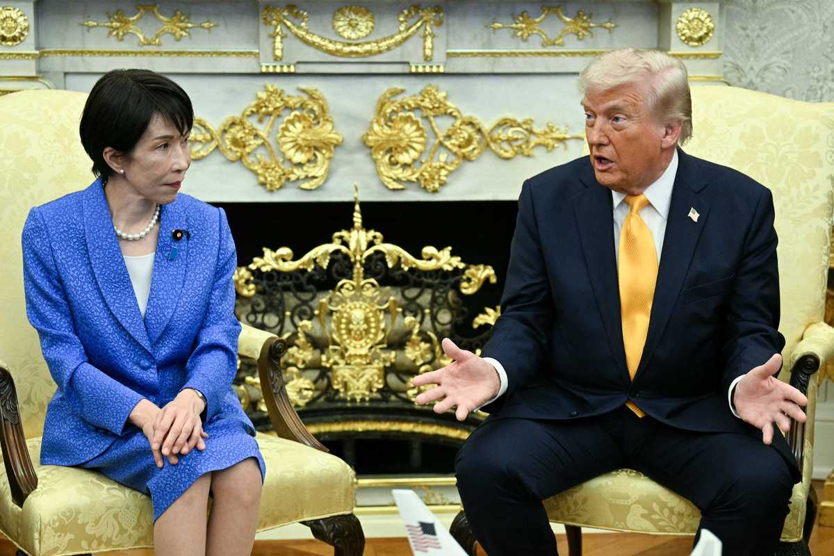 Left, Japanese prime minister Sanae Takaichi, looking at Donald Trump, right, with his arms and hands iout in front of him. Both are sat in cream chairs in the in the Oval Office.