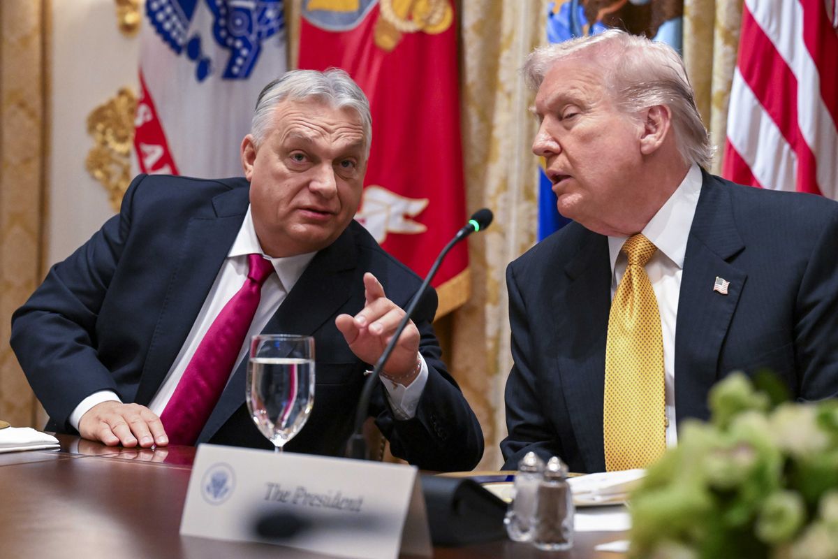 Left, Viktor Orbán points at someone off-camera in front of him. Right, US president Donald Trump listens. They are both sat at a wooden desk.