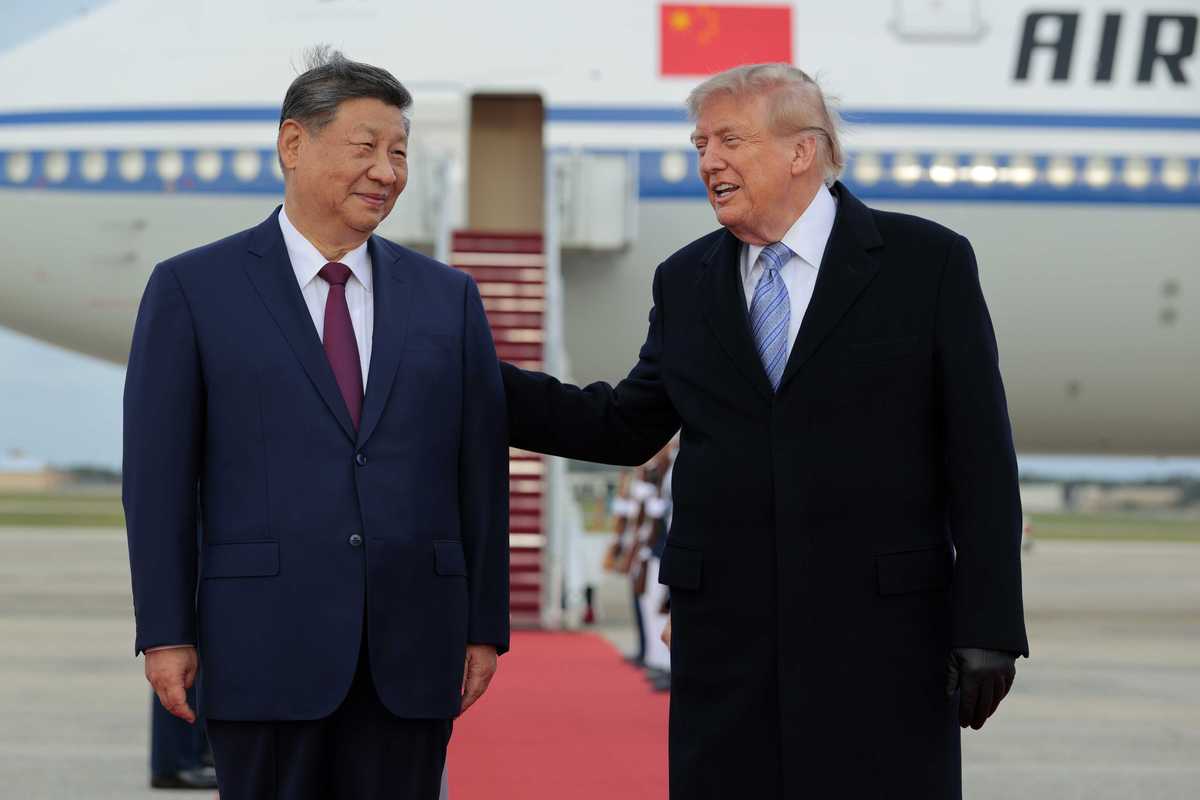 Left, Xi Jinping and right, Donald Trump, smiling on an airfield.