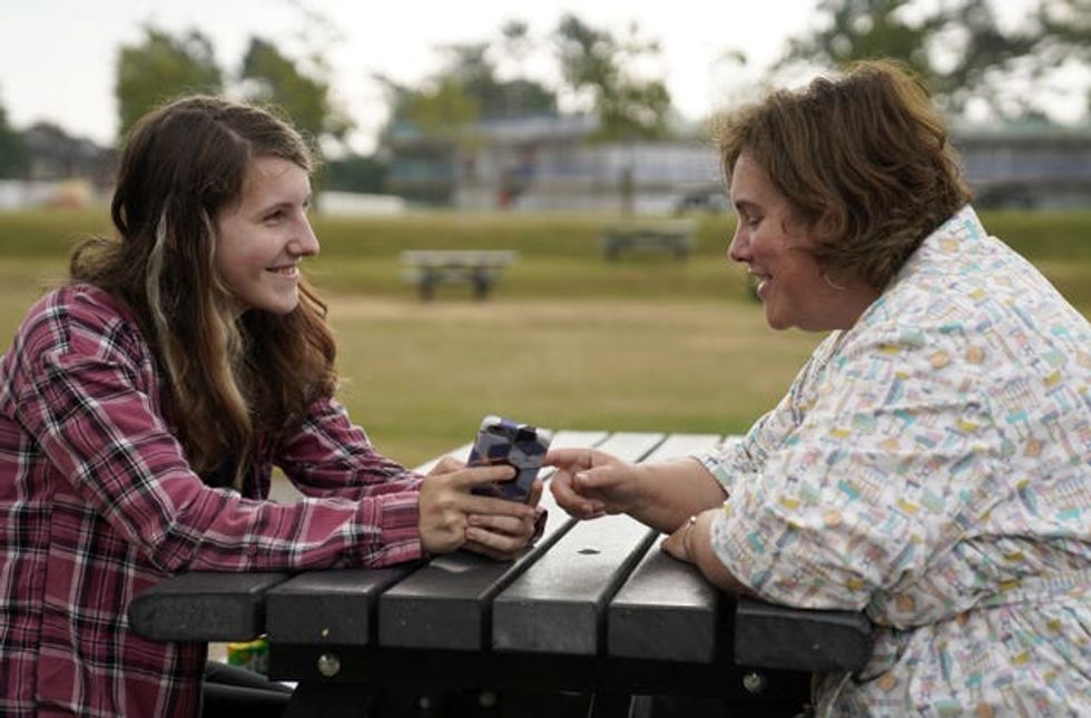 Leyna McQuillin, left, looks at her results on her phone with her mother Michelle McQuillin at Peter Symonds College, Winchester, Hampshire