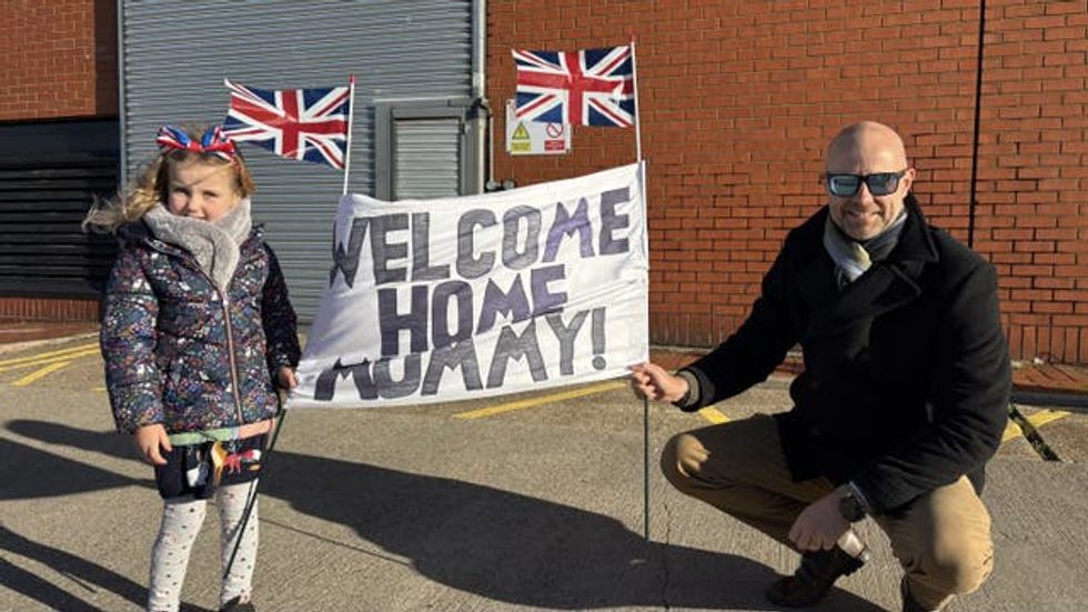 Lieutenant Simon Hall with his daughter Ophelia wait to welcome home his wife Lieutenant Commander Phoebe Hall