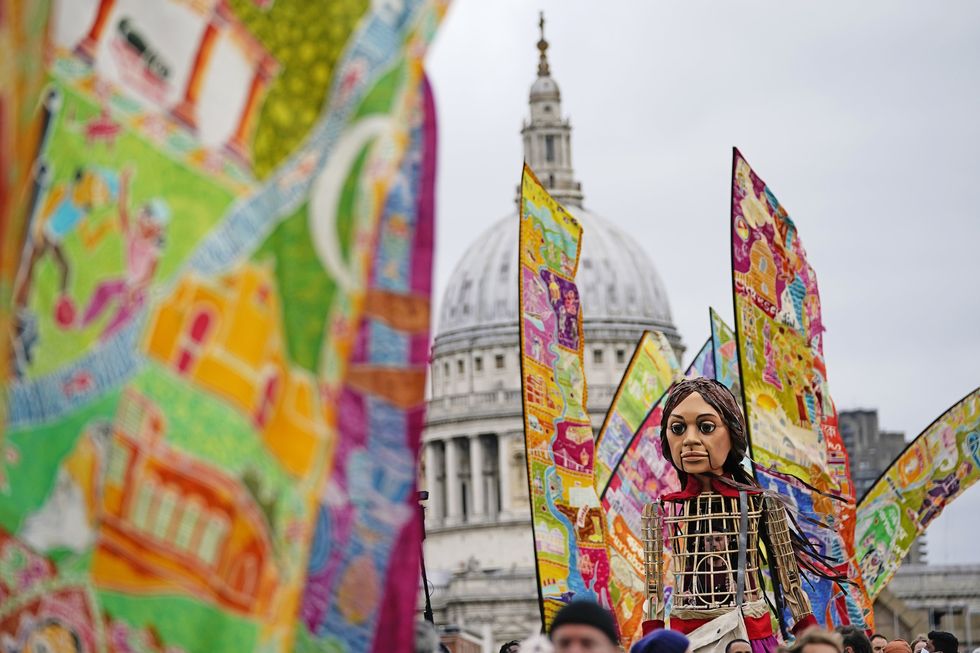 Little Amal walks over the Millennium Bridge in London (Aaron Chown/PA)