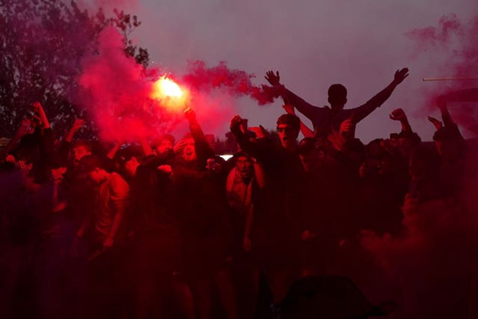 Liverpool fans celebrate victory in the Premier League outside Anfield, Liverpool.