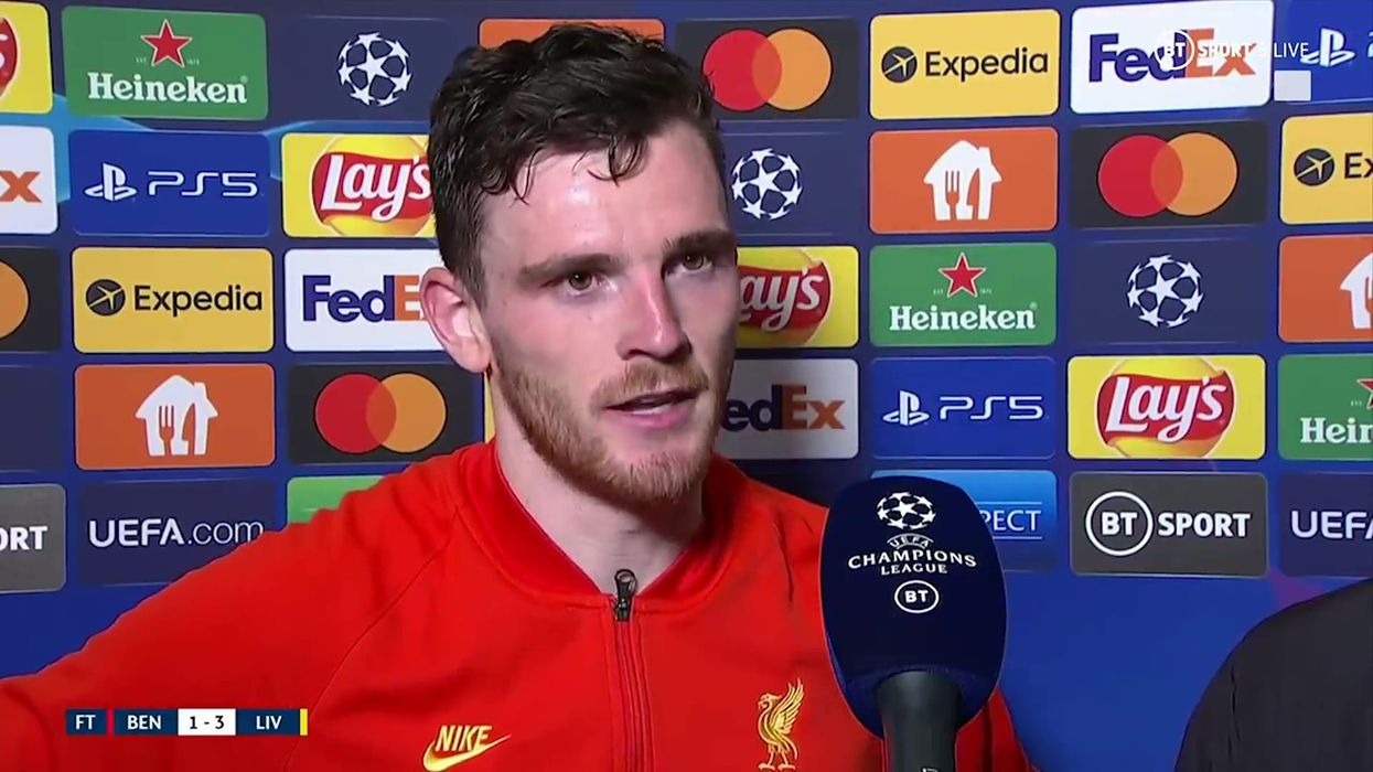 Liverpool player Andy Robertson reacts to being pelted with lighters by fans