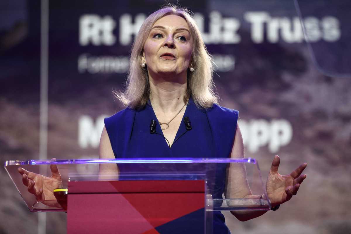 Liz Truss speaks behind a transparent lectern at CPAC GB.