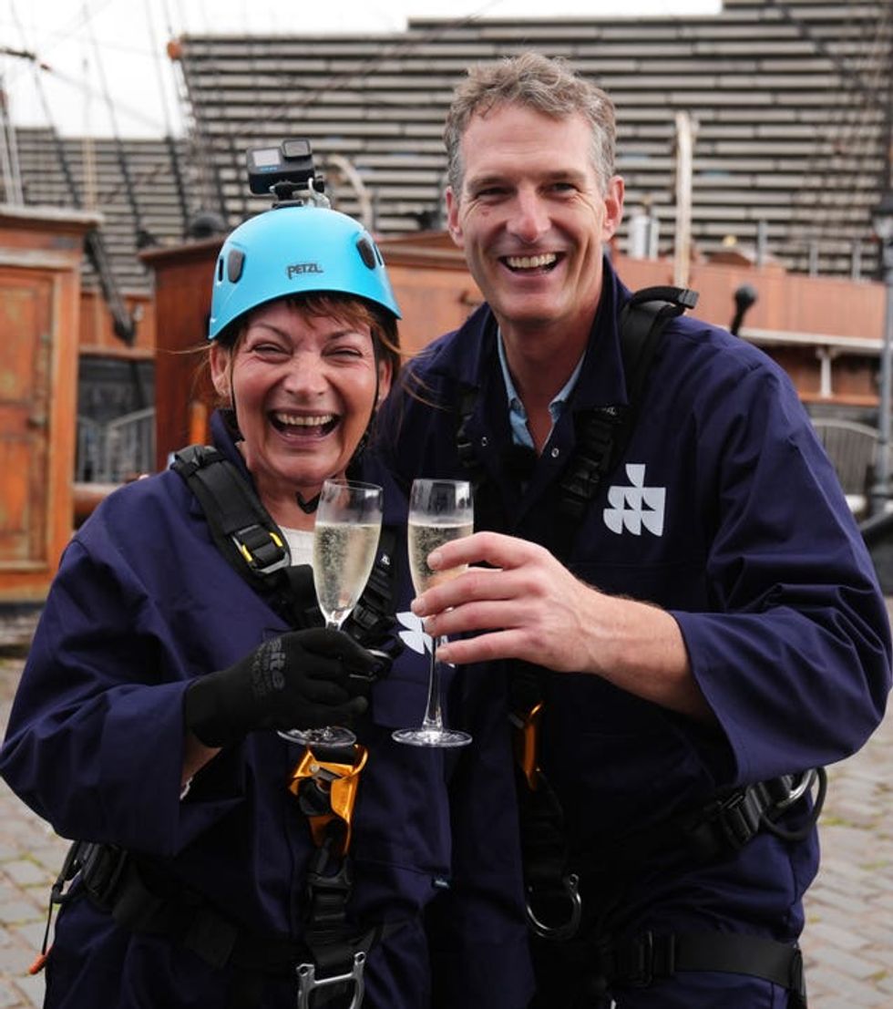 Lorraine Kelly and Dan Snow smiling while holding filled champagne glasses