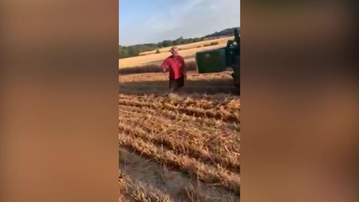 Raging man blocks combine harvester for getting dust on his sandwiches