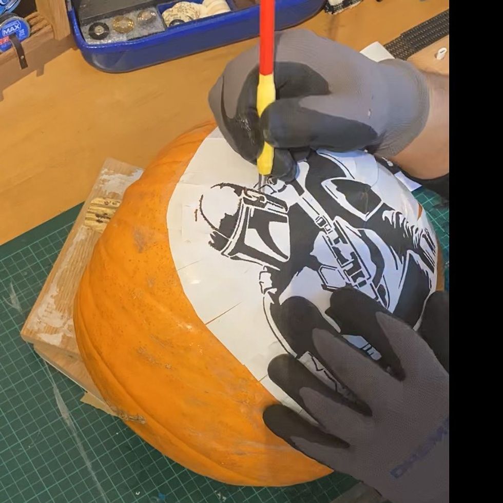 Man carving on to pumpkin
