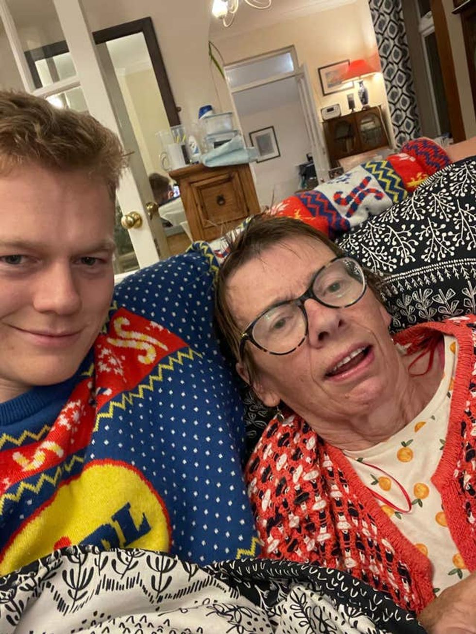 Man dressed in Lidl Christmas jumper and sat next to his mother who is wearing glasses