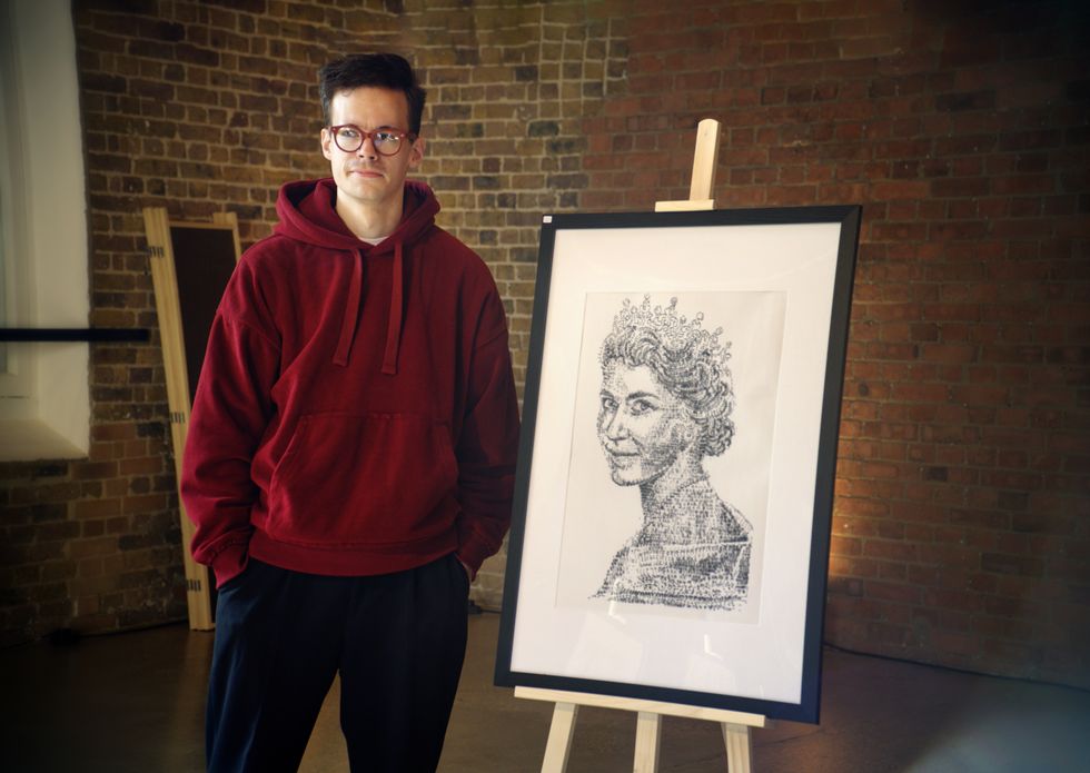 Man in red hoodie and glasses next to a portrait of The Queen