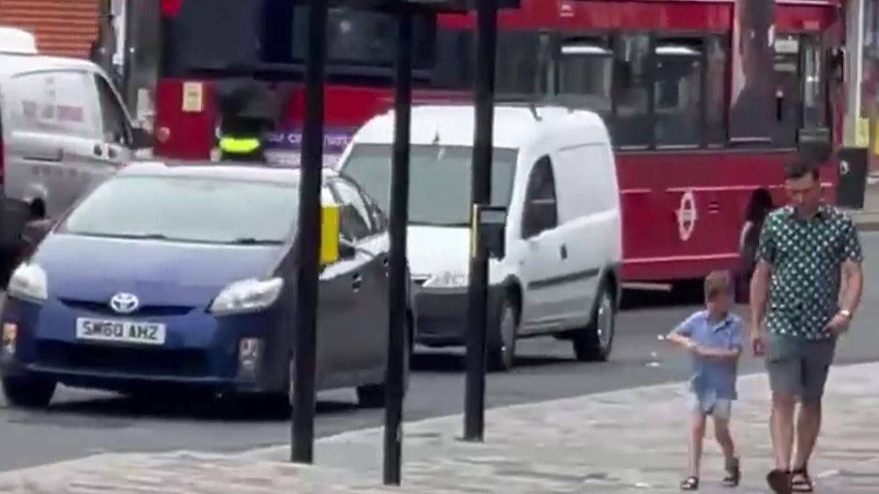 Man spotted clinging to the back of a moving bus in North-West London