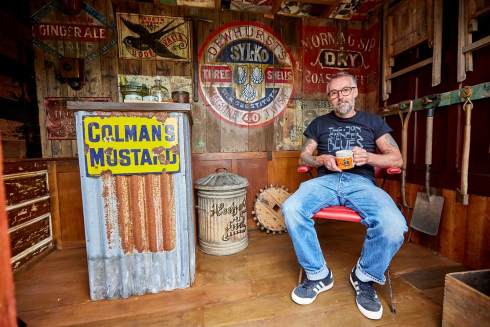 Man sits inside the shed he made