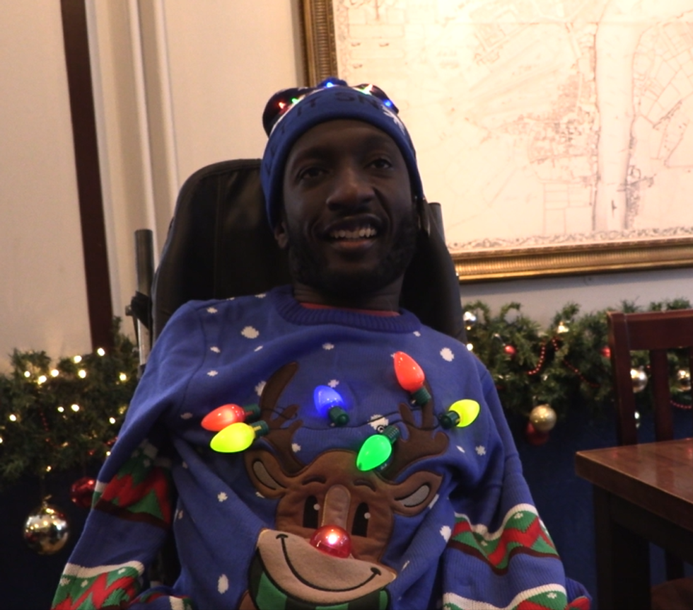 Man smiling and wearing festive jumper