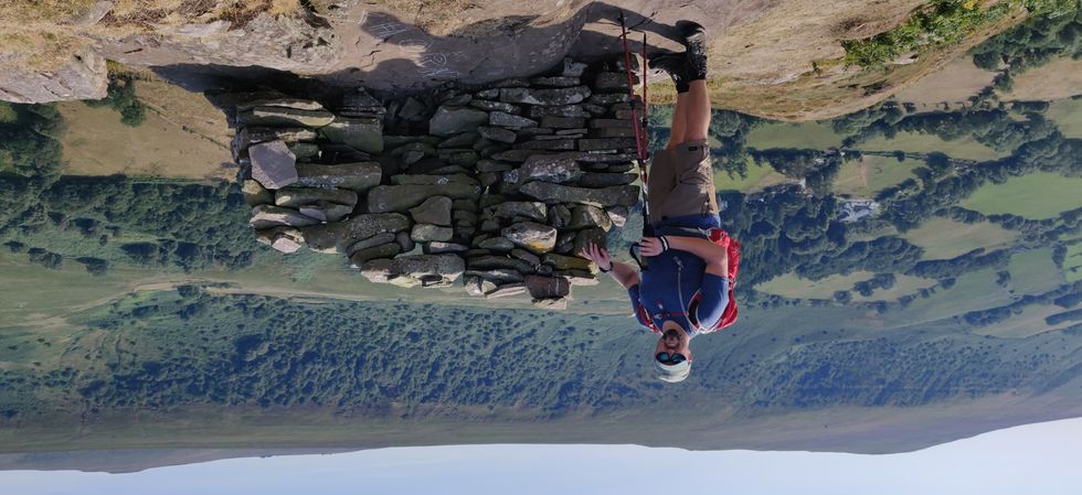 Man standing next to a heap of rocks