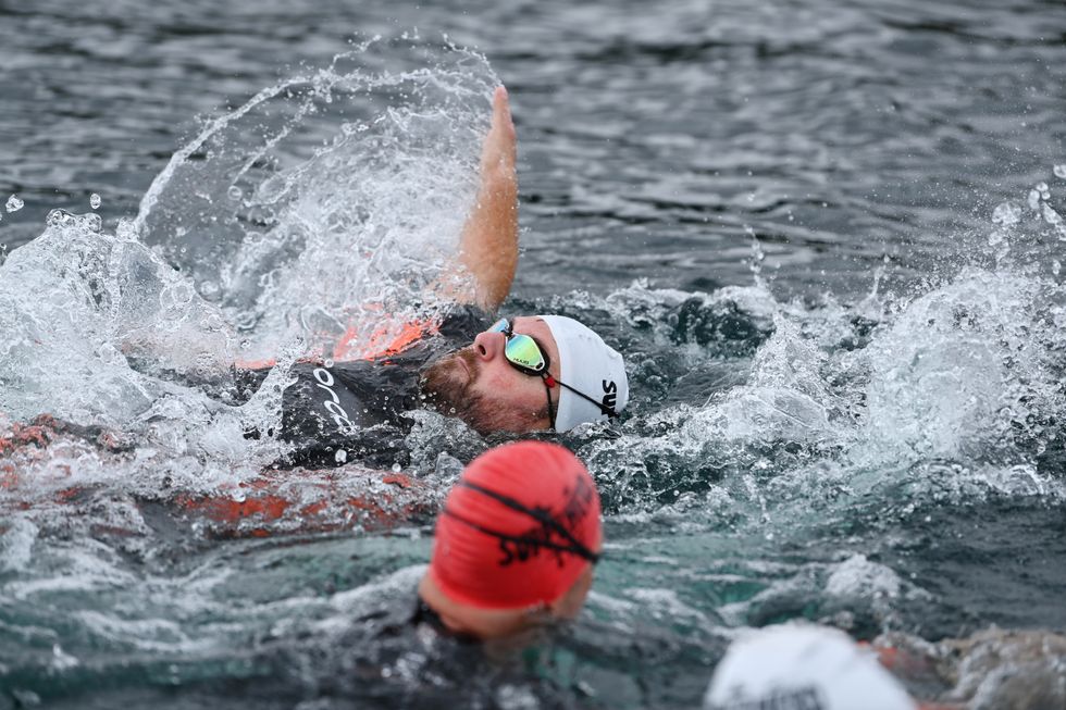 Man swimming with a red swimming cap on his head