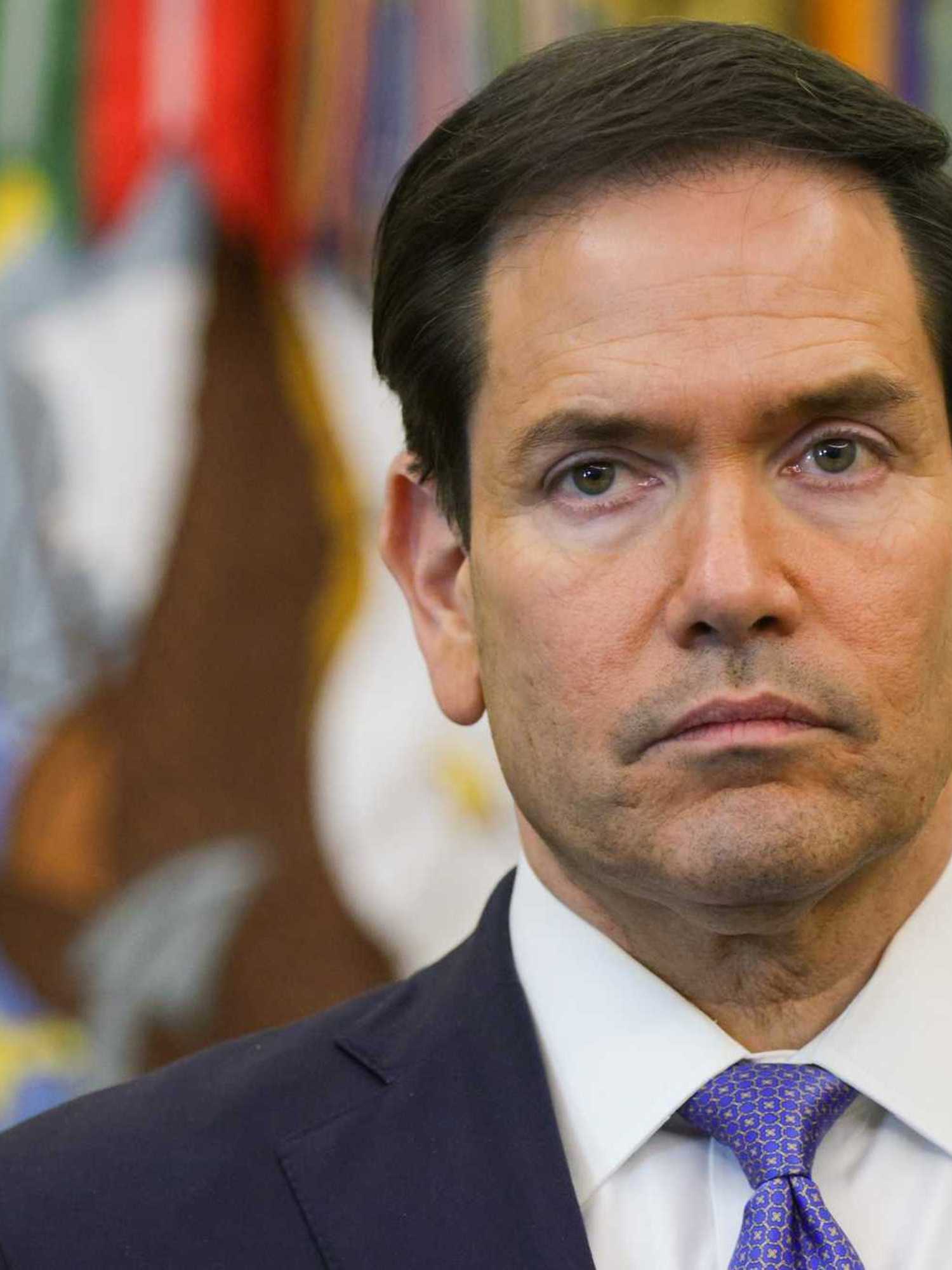 Marco Rubio, a white man with short black hair and neutral facial expression, in the Oval Office.