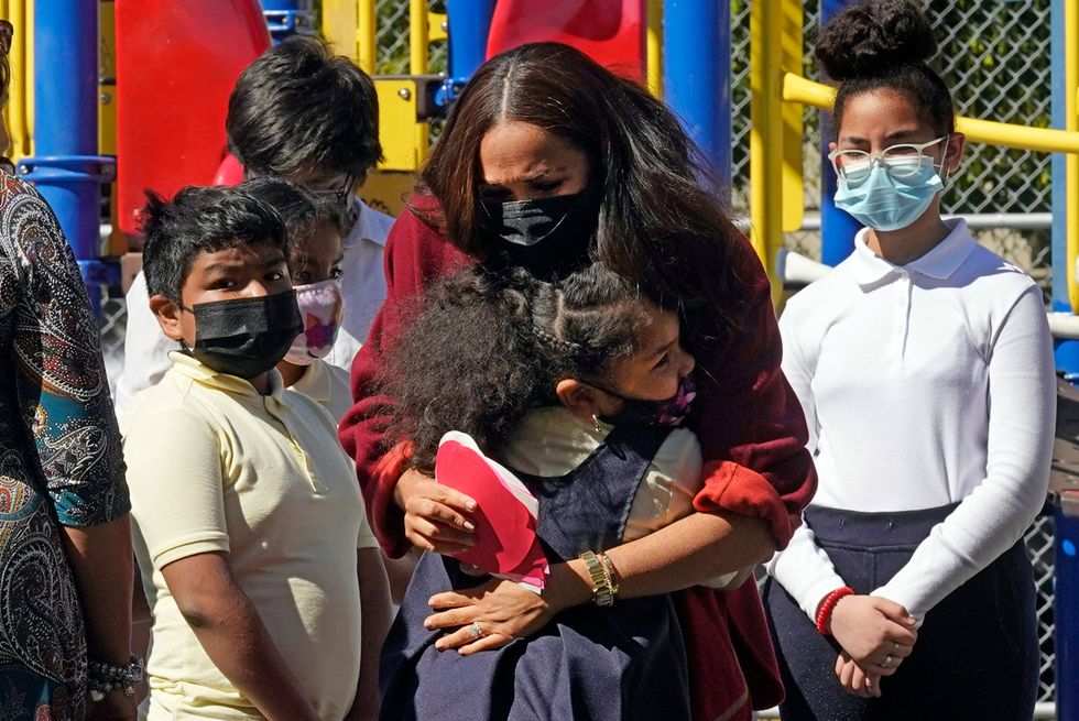 Meghan is hugged by a student (Richard Drew/PA)