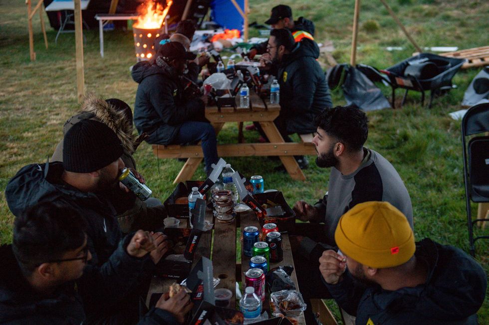 Members of Saltley Stallions Football Club eat together after fasting during Ramadan