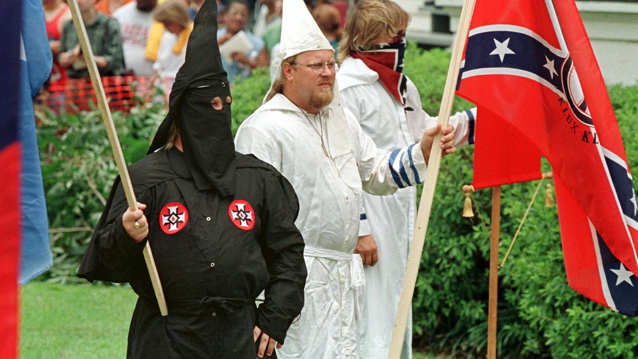 <p>Members of the Ku Klux Klan stand outside the courthouse lawn 27 June in Jasper, Texas. The white-supremist KKK met in Jasper to deny involvement in the killing of an African-American resident by three white men earlier this month. </p>