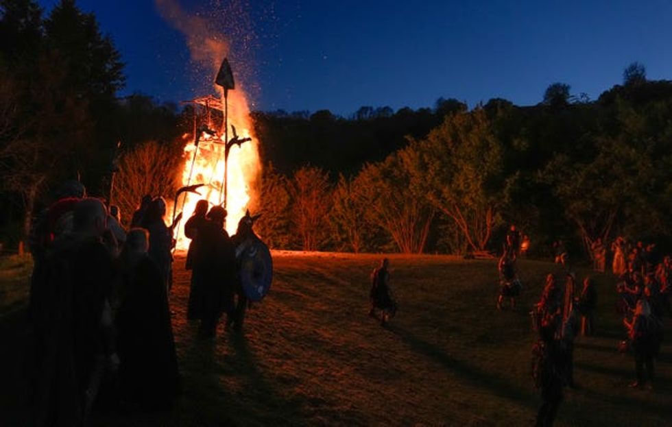 Members of the Pentacle Drummers perform in front of a burning wicker man during the Beltain Celtic Fire Festival at Butser Ancient Farm, near Waterlooville, Hampshire