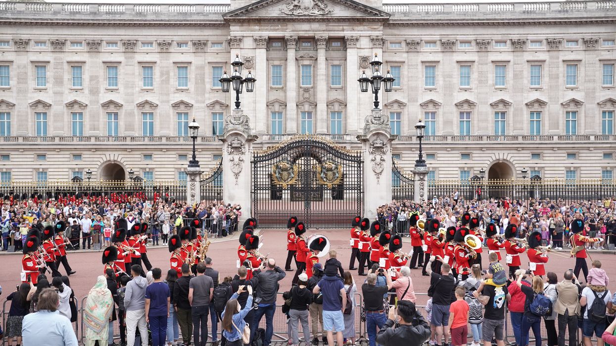 Members of the public watch the Band of The Coldstream Guards marching during the Changing the Guard ceremony at Buckingham Palace (Kirsty O’Connor/PA)