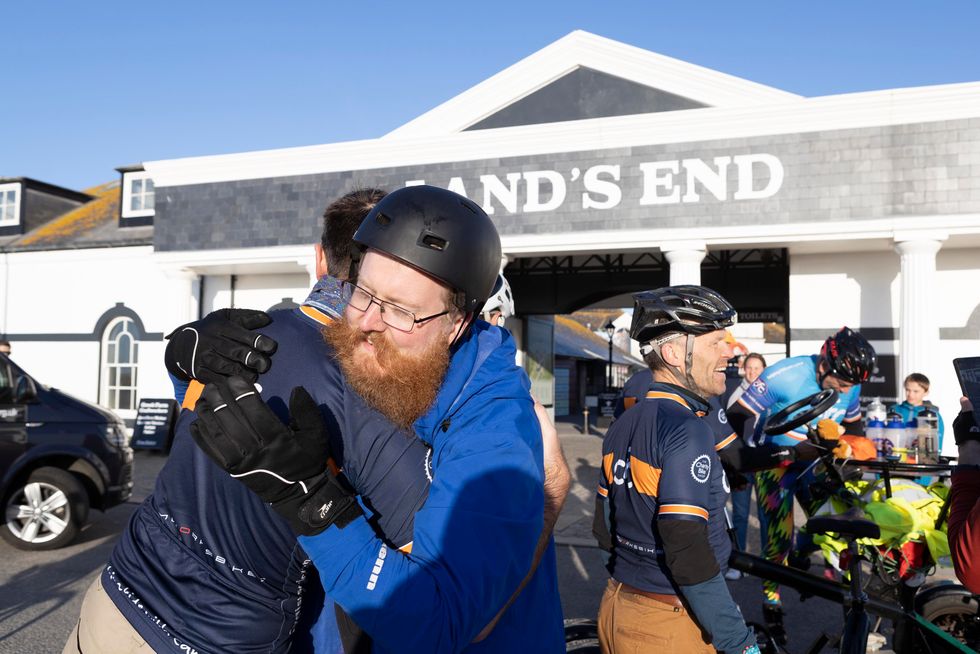 Members of the team embrace after arriving at Land's End.