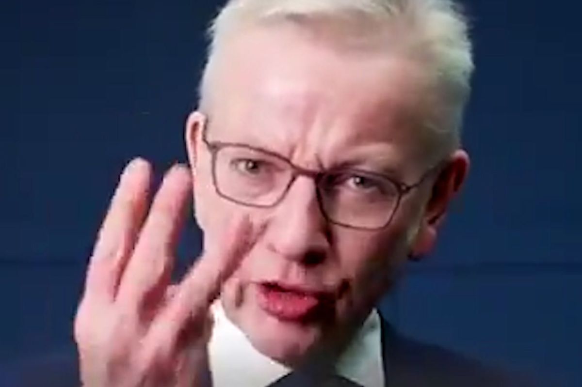 Michael Gove holds up three fingers while speaking to the camera.