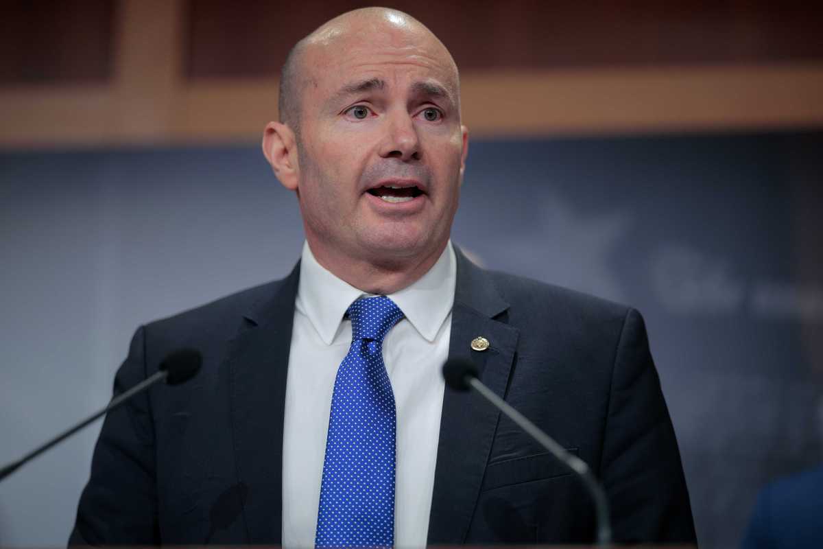 Mike Lee, a bald white man with a black suit and blue tie.