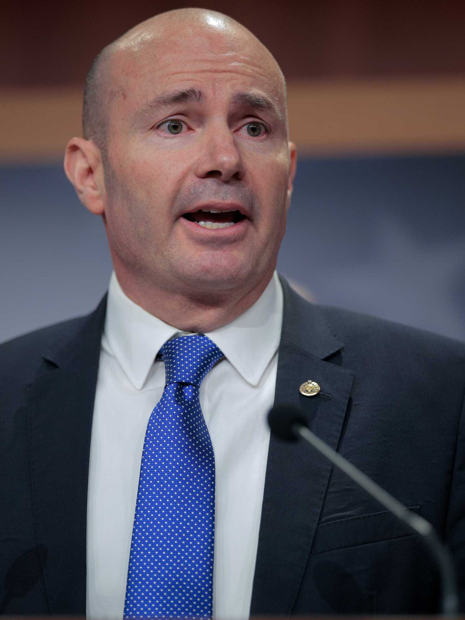 Mike Lee, a bald white man with a black suit and blue tie.